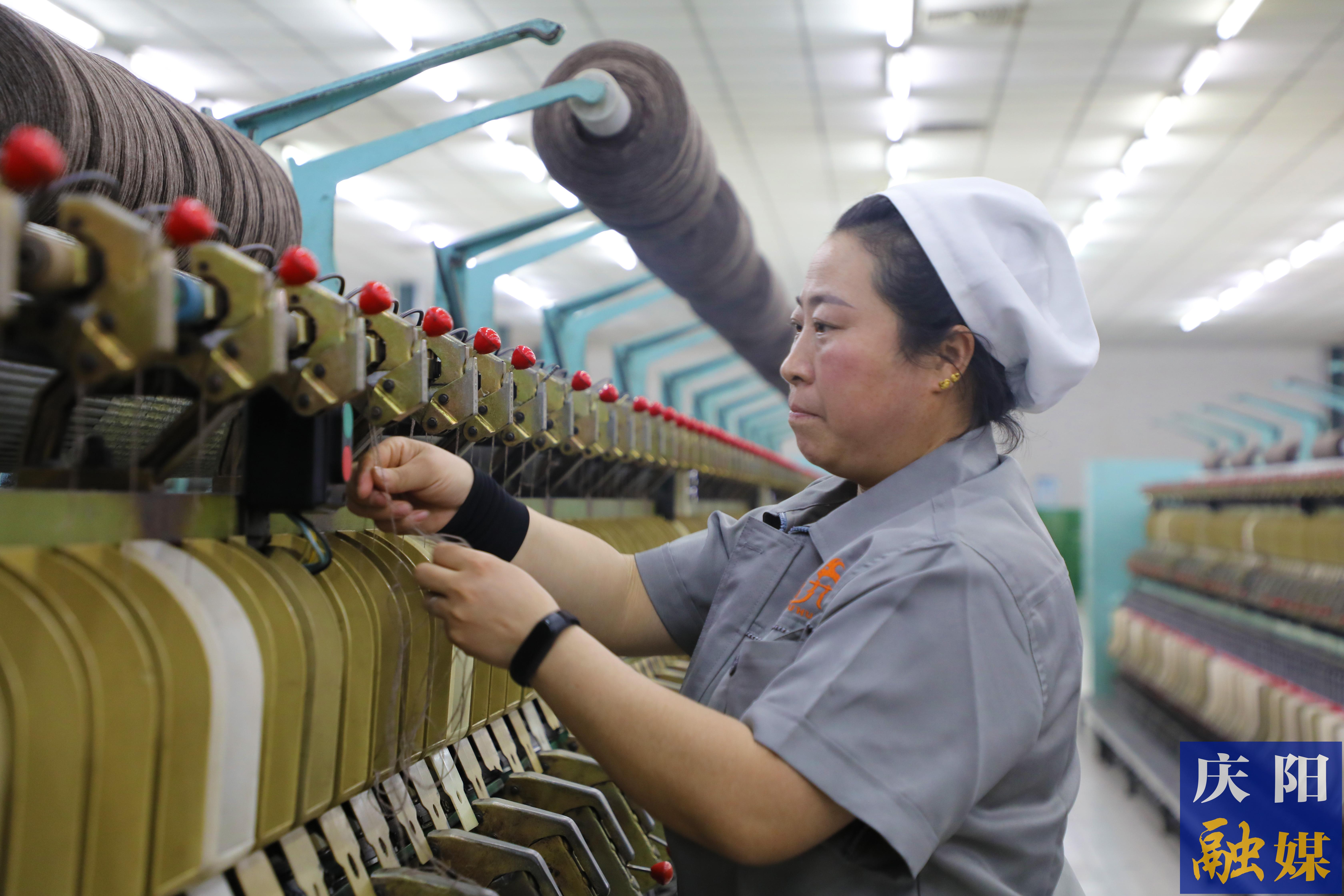 在鎮(zhèn)原縣解語花山羊絨制品有限責(zé)任公司紡紗車間，擋車工龐小麗熟練地操作著機(jī)器。 慶陽融媒記者 閆慧 攝